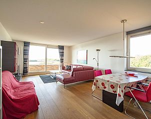 Dining room with red chairs in Duinerei C103 Groote Keeten vacation home in Callantsoog, North Holland.
