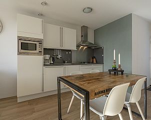 Dining area with wooden table in Duinerei C202 Groote Keeten, vacation home in Callantsoog, North Holland.