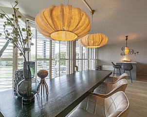 Dining room in Strandleven 006 Groote Keeten, Callantsoog with modern lighting and views of the North Sea coast.