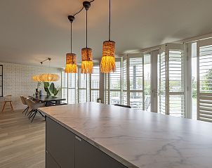 Illuminated dining area in Strandleven 006 Groote Keeten, vacation home in Callantsoog, overlooking the garden.