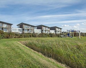 Green surroundings around Beach Life 103 Groote Keeten vacation home in Callantsoog with playground.