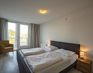 Cozy bedroom in Strandleven 103 Groote Keeten vacation home in Callantsoog with access to balcony.