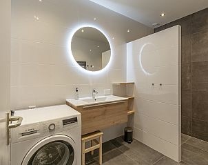Modern bathroom with washing machine in Wijde Blick 112 Callantsoog, vacation home on the North Sea coast.