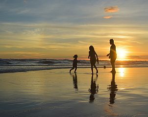 Family enjoys beach at sunset near Wijde Blick 112 Callantsoog, vacation home on North Sea coast.