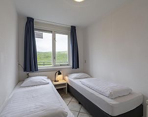 Slaapkamer met uitzicht op de duinen in Wijde Blick 310 Callantsoog, Noord-Holland