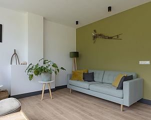 Modern living room of Previnaireweg 34 Callantsoog vacation home with comfortable sofa.