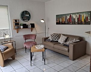 Outdoor terrace of NH549 in Callantsoog, North Sea coast, with deck chairs and umbrella for sunny days.