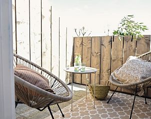 Rustic picnic table on the terrace of Holiday home in Callantsoog, North Sea coast, North Holland surrounded by greenery.
