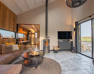 Cozy living room of Spoiled Wheel in Callantsoog with fireplace and modern decor.