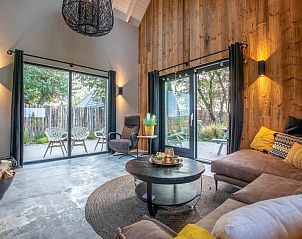 Bright living room of Spoelde wiel in Callantsoog with access to the terrace and natural light.