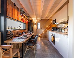 Dining area and kitchen in Spoelde wheel vacation home in Callantsoog with wooden details and modern appliances.