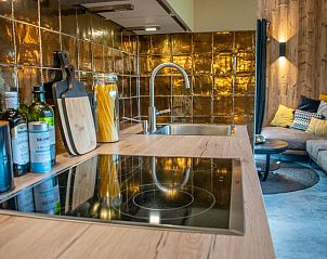 Kitchen countertop and cooktop by Spoiled Wheel in Callantsoog with stylish tile wall.