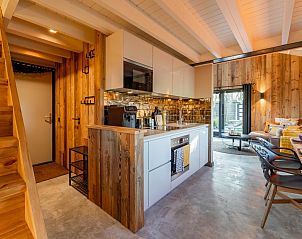 Kitchen and stairs upstairs in Spoelde wheel vacation home in Callantsoog with modern furnishings.