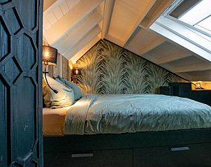 Cozy bedroom in Spoiled Wheel vacation home in Callantsoog with wooden accents and lighting.