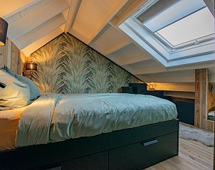 Bright bedroom in Spoelde wiel vacation home in Callantsoog with unique wallpaper and comfortable bed.