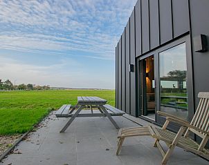 Terrace of Spoelde wiel vacation home in Callantsoog with picnic table and view of fields.