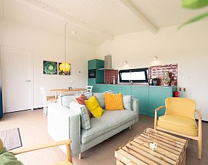 Stylish living room of Royal Dune 4, Callantsoog, with modern kitchen and colorful furnishings.