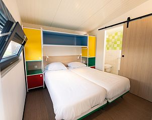 Second bedroom in Royal Dune 4, Callantsoog, with colorful closet and access to bathroom.