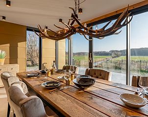 Stylish dining area with views of nature in De Bonte Specht vacation home, Callantsoog.