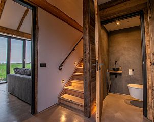 Hall with wooden staircase and modern bathroom in De Bonte Specht vacation home, Callantsoog.