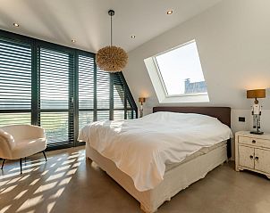 Bedroom with modern design and views of nature in De Bonte Specht vacation home, Callantsoog.