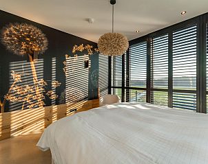 Bedroom with decorative wall and lots of light in De Bonte Specht vacation home, Callantsoog, North Sea coast.