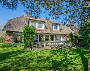 Landhuis Duinzicht in Callantsoog, een charmant vakantiehuis aan de Noordzeekust met rieten dak en zonnig terras te midden van groene natuur.