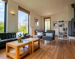 Gezellige woonkamer van Landhuis Duinzicht in Callantsoog, Noordzeekust, Noord-Holland, met uitzicht op de natuur en comfortabele zithoek.