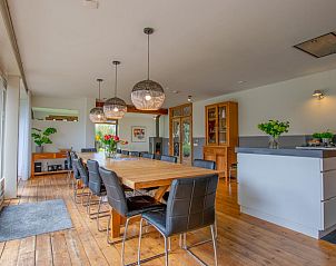 Gezellige eetkamer in Landhuis Duinzicht, een vakantiehuis in Callantsoog aan de Noordzeekust, Noord-Holland, met houten vloeren en moderne inrichting.
