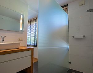 Moderne badkamer in Landhuis Duinzicht, vakantiehuis in Callantsoog aan de Noordzeekust, Noord-Holland, met ruime inloopdouche en elegant wastafelmeubel.