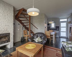 Cozy living room of Abbestederweg 24A Callantsoog with fireplace and stairs in North Holland