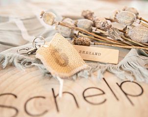 Key chain of Holiday home in Callantsoog, North Sea coast, North Holland, on a rustic background.