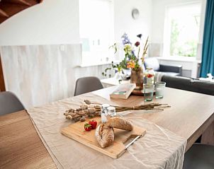 Dining table at Holiday cottage in Callantsoog, North Sea coast, North Holland, with fresh bread and flowers.