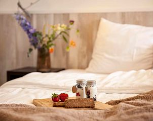 Breakfast in bed at Holiday home in Callantsoog, North Sea coast, North Holland, with flowers in the background.
