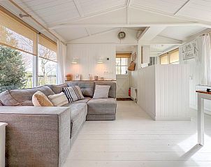 Gezellige woonkamer van vakantiehuis Sol in Callantsoog met comfortabele bank.