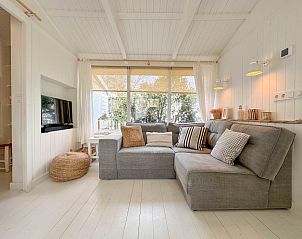 Stijlvolle woonkamer van vakantiehuis Sol in Callantsoog met veel natuurlijk licht.