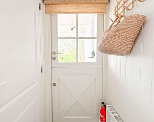 Ingang van vakantiehuis Sol in Callantsoog met rieten tas.