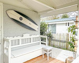 Veranda van vakantiehuis Sol in Callantsoog met surfplankdecoratie.