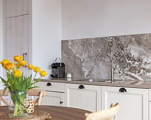 Detail of the kitchen in Cottage in Callantsoog, vacation home on the North Sea coast with elegant finishes.