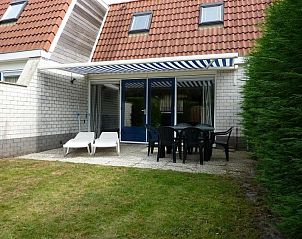 Veranda of Zwanenwater 1 vacation home in Callantsoog, North Sea coast, North Holland with deck chairs and dining table.
