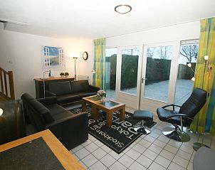 Spacious sitting area in vacation home Zwanenwater 2, Callantsoog, with comfortable sofas and access to the garden.