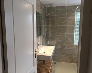 Zonnig terras van NH072 vakantiehuis in Groet, Noordzeekust, perfect voor buitenontspanning.