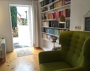 Lichte eetruimte in NH072 vakantiehuis, Groet, Noordzeekust, met houten vloer en moderne inrichting.