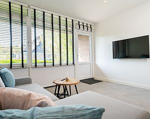 Moderne woonkamer NH496 vakantiehuis Groet Noordzeekust met open keuken en comfortabele zithoek.