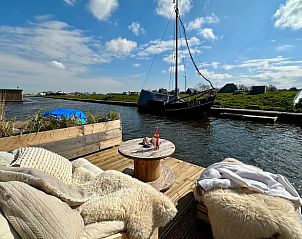 Ontspan op de comfortabele steiger bij Huisje in Groet, vakantiehuis aan de Noordzeekust, Noord-Holland.