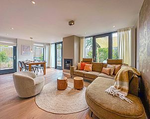 Gezellige woonkamer van vakantiehuis Duinland in Egmond aan den Hoef, Noordzeekust, met ruime zithoek en uitzicht op de tuin.