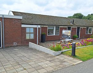Vakantiehuisje in Egmond aan den Hoef met ruime patio en kleurrijke bloemen aan de Noordzeekust, Noord-Holland.
