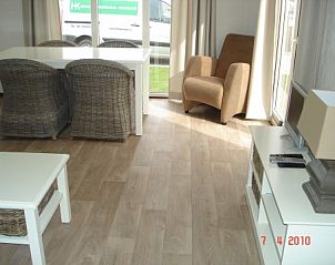 Lichte woonkamer van chalet IJmuiden in Noord-Holland met ruime zithoek en eettafel.