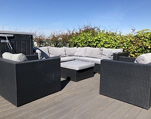 Buitenlounge op het terras van Zee en duin chalet, IJmuiden, met uitzicht op de Noordzeekust.