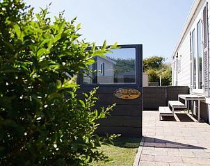 Ingang van Zee en duin chalet, IJmuiden, met zonnige tuin aan de Noordzeekust van Noord-Holland.